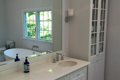 Bathroom - transitional master bathroom idea in Boston with an undermount sink, recessed-panel cabinets, white cabinets and solid surface countertops