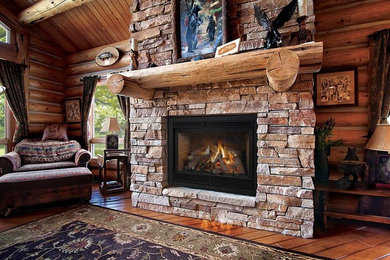 Family room - mid-sized rustic open concept medium tone wood floor family room idea in Denver with beige walls, a standard fireplace, a stone fireplace and no tv