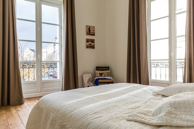 Imagen de dormitorio clásico renovado con paredes beige, suelo de madera en tonos medios y suelo marrón
