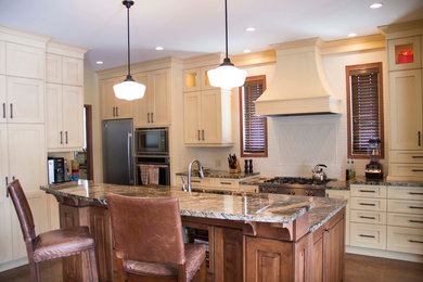 Mid-sized transitional eat-in kitchen photo in Other with an undermount sink, recessed-panel cabinets, white cabinets, granite countertops, white backsplash, stainless steel appliances and an island
