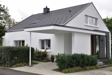 Dreistöckiges Modernes Haus mit Faserzement-Fassade, grauer Fassadenfarbe, Satteldach, Ziegeldach und schwarzem Dach in Stuttgart