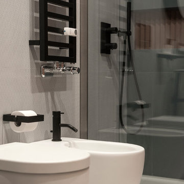 Bagno ospiti | Dettaglio sanitari con rubinetteria nera e termoarredo