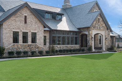 Cottage two-story stone and shingle house exterior idea in Houston with a tile roof and a gray roof
