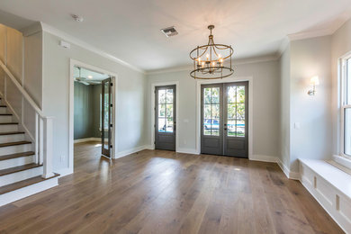 Inspiration for a mid-sized transitional medium tone wood floor and brown floor entryway remodel in Orlando with gray walls and a gray front door