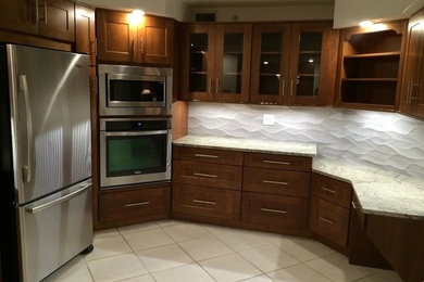 Mid-sized trendy u-shaped ceramic tile and white floor enclosed kitchen photo in Orlando with a double-bowl sink, shaker cabinets, medium tone wood cabinets, granite countertops, white backsplash, cement tile backsplash, stainless steel appliances and no island