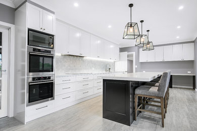 Contemporary single-wall kitchen in Sydney with shaker cabinets, black cabinets and quartz benchtops.