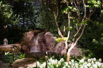 Ejemplo de jardín tradicional renovado extra grande en patio trasero con fuente