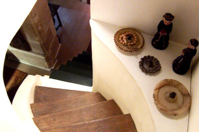 Aménagement d'un escalier courbe méditerranéen avec des marches en bois.
