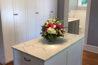 Example of a large transitional gender-neutral medium tone wood floor and brown floor dressing room design in Boston with shaker cabinets and white cabinets