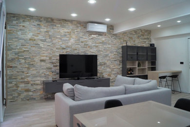 Imagen de salón con barra de bar abierto contemporáneo de tamaño medio sin chimenea con paredes beige, suelo laminado, televisor colgado en la pared y suelo beige