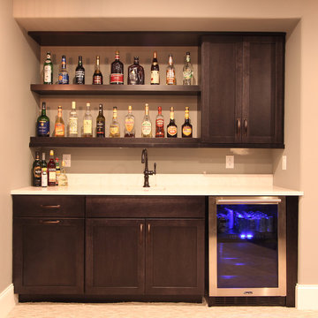 Lower Level Wet Bar with Grey Stained Cabinets and Thick Shelves