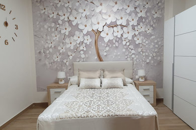 Diseño de dormitorio principal y gris y blanco tradicional renovado de tamaño medio con paredes blancas, suelo de madera en tonos medios y papel pintado