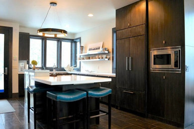 Inspiration for a contemporary l-shaped open concept kitchen remodel in Other with flat-panel cabinets, gray cabinets, solid surface countertops, paneled appliances and an island