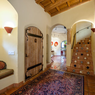 Photo of a mediterranean curved metal railing staircase in Other with terracotta treads and terracotta risers.