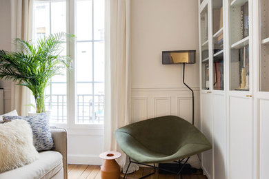 Idée de décoration pour un petit salon design ouvert avec une bibliothèque ou un coin lecture, un mur blanc, un sol en bois brun, un téléviseur dissimulé, aucune cheminée et un sol marron.
