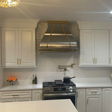 Custom Stainless Steel Range Hood with Brass Accents in a Luxury Kitchen