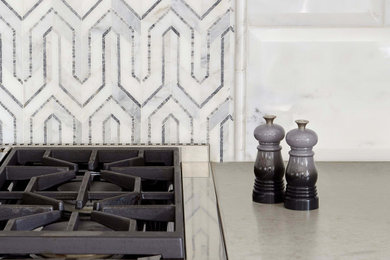 Inspiration for a scandinavian eat-in kitchen remodel in Denver with flat-panel cabinets, white cabinets, white backsplash, marble backsplash, stainless steel appliances and gray countertops