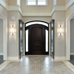 Esempio di un ingresso o corridoio tradizionale con una porta in legno scuro e pavimento grigio