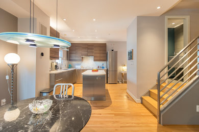 Open concept kitchen - mid-sized modern l-shaped light wood floor and beige floor open concept kitchen idea in DC Metro with an undermount sink, flat-panel cabinets, stainless steel cabinets, marble countertops, white backsplash, stone slab backsplash, stainless steel appliances, an island and white countertops