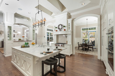 Elegant u-shaped dark wood floor eat-in kitchen photo in Portland with an undermount sink, raised-panel cabinets, white cabinets, beige backsplash and stainless steel appliances