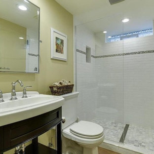 Esempio di una stanza da bagno con doccia minimalista di medie dimensioni con ante a persiana, ante in legno bruno, doccia alcova, WC a due pezzi, piastrelle bianche, piastrelle in ceramica, pareti gialle, pavimento in cemento, lavabo integrato, top in superficie solida, pavimento arancione, porta doccia a battente e top bianco
