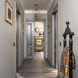 Klassisk inredning av en liten hall, med grå väggar, mörkt trägolv och grått golv