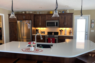 Example of a mid-sized classic u-shaped dark wood floor and brown floor eat-in kitchen design in Minneapolis with a double-bowl sink, dark wood cabinets, quartz countertops, white backsplash, stainless steel appliances, an island and white countertops