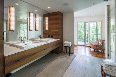 Design ideas for a contemporary bathroom in Other with flat-panel cabinets, dark wood cabinets, an alcove shower, grey walls, a vessel sink, grey floor, a hinged shower door and white benchtops.