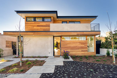 Imagen de fachada de casa marrón y negra actual de tamaño medio de dos plantas con revestimiento de madera, tejado plano, tejado de metal y panel y listón