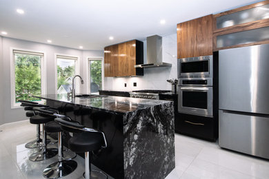 Example of a large trendy single-wall porcelain tile and gray floor open concept kitchen design in Ottawa with an undermount sink, flat-panel cabinets, dark wood cabinets, granite countertops, white backsplash, porcelain backsplash, stainless steel appliances, an island and black countertops