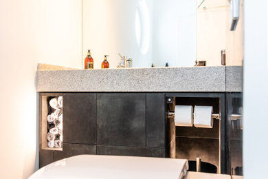 Moderne Gästetoilette mit grauen Schränken, grauer Waschtischplatte und eingebautem Waschtisch in Nürnberg