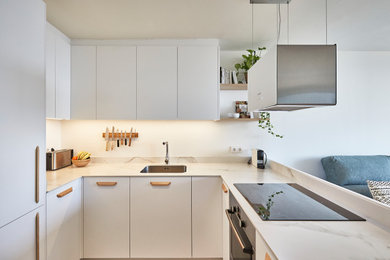 Imagen de cocina nórdica con puertas de armario blancas y encimeras blancas