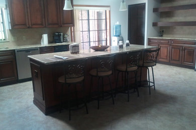 Eat-in kitchen - mid-sized transitional u-shaped porcelain tile eat-in kitchen idea in Orlando with a double-bowl sink, raised-panel cabinets, medium tone wood cabinets, granite countertops, beige backsplash, ceramic backsplash, stainless steel appliances and an island
