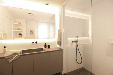 Ejemplo de cuarto de baño principal, único y a medida actual de tamaño medio con armarios tipo mueble, ducha a ras de suelo, baldosas y/o azulejos blancos, paredes blancas y lavabo encastrado