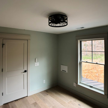 Cozy Modern Farmhouse Office: Light Oak Floors, Soft Green Walls, and Warm Light
