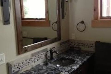 Beige tile and stone tile bathroom photo in Boise with a drop-in sink, raised-panel cabinets, dark wood cabinets and beige walls