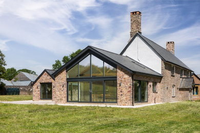 Photo of a large farmhouse house exterior in Devon with stone cladding.