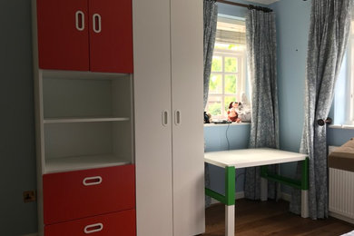 Photo of a medium sized bedroom in Sussex with blue walls, medium hardwood flooring and brown floors.