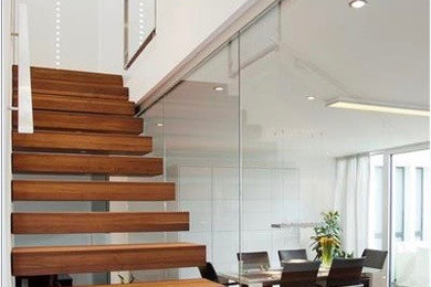 ケルンにある高級な広いコンテンポラリースタイルのおしゃれな階段 (ガラスフェンス) の写真
