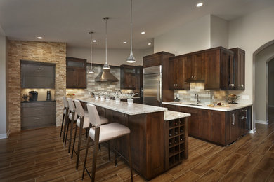 This is an example of a large transitional l-shaped kitchen in Phoenix with an undermount sink, stainless steel appliances, dark hardwood floors, with island and brown floor.