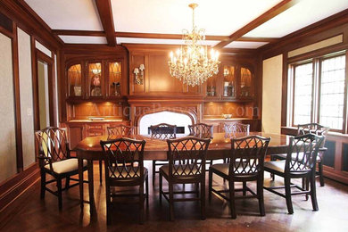 Photo of a large classic kitchen/dining room in New York with beige walls, dark hardwood flooring, a standard fireplace and a stone fireplace surround.