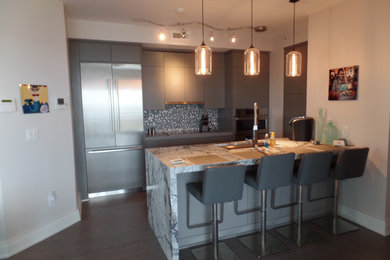 Example of a mid-sized trendy l-shaped dark wood floor and brown floor eat-in kitchen design in Other with an integrated sink, flat-panel cabinets, gray cabinets, marble countertops, gray backsplash, mosaic tile backsplash, stainless steel appliances, an island and gray countertops