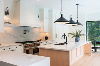 Large trendy l-shaped light wood floor and beige floor eat-in kitchen photo in Toronto with a single-bowl sink, shaker cabinets, white cabinets, quartz countertops, white backsplash, an island, white countertops, stone slab backsplash and stainless steel appliances