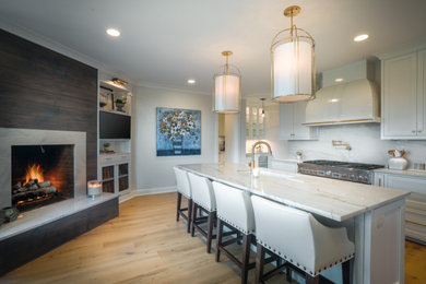 Inspiration for a large modern light wood floor kitchen remodel in Nashville with white cabinets, quartzite countertops, stone slab backsplash, stainless steel appliances and an island