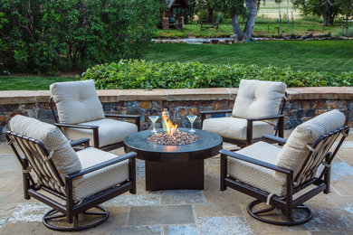 Photo of a small country backyard patio in Denver with a fire feature, no cover and natural stone pavers.