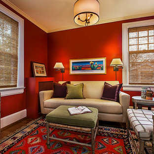 Immagine di un piccolo soggiorno bohémian chiuso con libreria, pareti rosse, parquet scuro, TV a parete e pavimento marrone