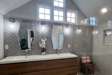 На фото: главная ванная комната среднего размера в современном стиле с плоскими фасадами, светлыми деревянными фасадами, серыми стенами, тумбой под две раковины и встроенной тумбой