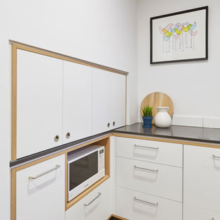 Идея дизайна: большая параллельная кухня в скандинавском стиле с кладовкой, накладной раковиной, фасадами с декоративным кантом, фасадами цвета дерева среднего тона, столешницей из бетона, белым фартуком, фартуком из плитки кабанчик, техникой из нержавеющей стали, пробковым полом и островом