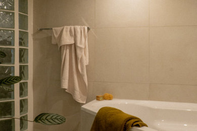 パリにある広いコンテンポラリースタイルのおしゃれなマスターバスルーム (コーナー型浴槽、グレーのタイル、グレーの壁、グレーの床) の写真
