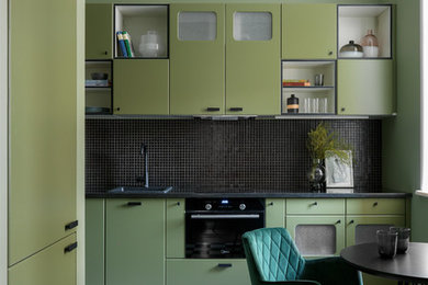 Small eclectic separate kitchen in Moscow with flat-panel cabinets, green cabinets, granite benchtops, black splashback, mosaic tile splashback, black appliances, porcelain floors, black benchtop, a drop-in sink, no island and multi-coloured floor.
